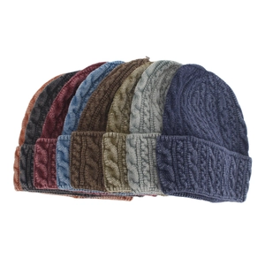 Detail view of winter cable knit beanies in multiple colors with ribbed cuff texture