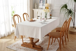 Close-up of white cotton tablecloth with delicate lace edges on a wooden dining table