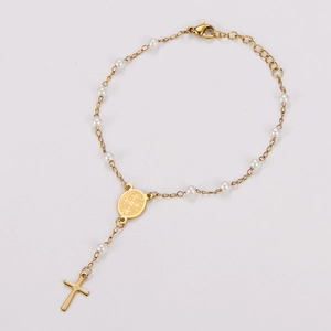 Gros plan d'un bracelet en acier inoxydable doré 18k avec perles blanches et pendentif croix
