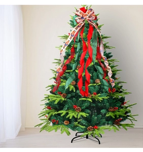 Détail du cimier de sapin de Noël avec rubans casse-noisette, baies rouges et pommes de pin