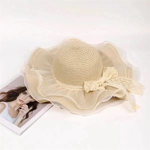 Elegant beige straw sun hat with organza ruffles and lace bow for beach vacation
