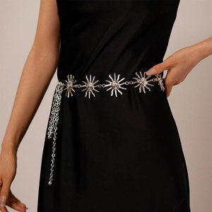 Detail of silver sun-face relief belt with metal links on smooth black fabric