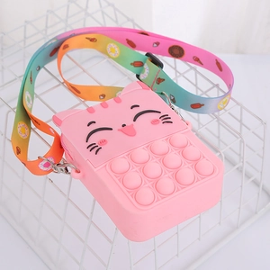Detail of pink silicone cat pop-it crossbody bag with rainbow donut print strap on white basket