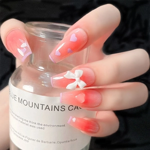 Detailed view of long square ombre press-on nails with 3D white bow and heart patterns
