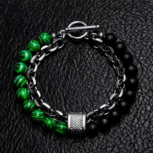 Macro shot of double-layer bracelet with green stone beads and matte black accents on leather