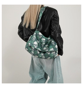 Detail of nylon tote bag with green skull and rose pattern worn over black leather jacket