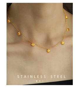 Detailed close-up of a gold stainless steel necklace with delicate scallop shell pendants