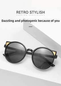 Detail of black cat-ear sunglasses featuring gold triangular metal accents and retro lenses