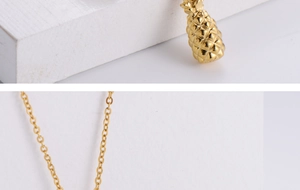 Detailed close-up of golden pineapple pendant with geometric texture on steel chain
