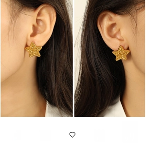 Detail of gold star earrings featuring unique wrinkled texture on model's ears