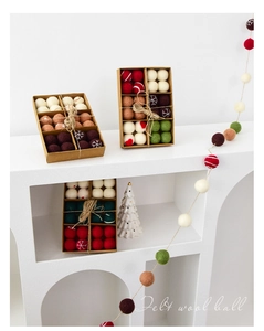 Close-up of wool felt Christmas balls in a kraft box with snowflake and heart patterns