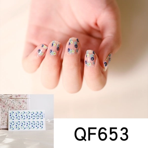 Detail view of blue floral wreath nail stickers QF653 on model's hand with packaging