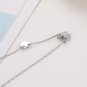 Macro shot of silver butterfly and heart pendant necklace with shiny O-chain link