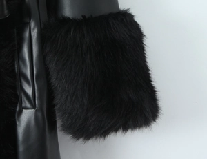 Detailed close-up of luxurious faux fur cuffs on a slim black long leather coat