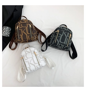Flat lay of mini backpacks in brown, black and white with all-over KC letter pattern