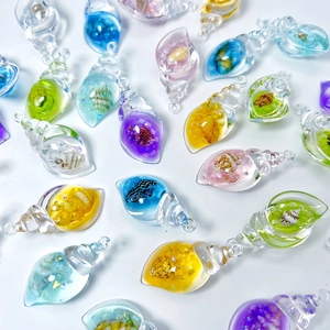 Close-up of colorful luminous acrylic conch pendants with real seashells inside for DIY crafts