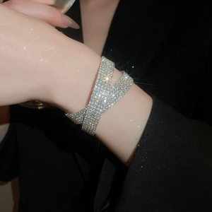 Vue macro détaillée du bracelet croisé argenté multicouche orné de strass étincelants
