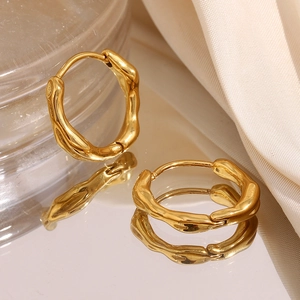 Macro view of gold plated stainless steel hoop earrings with textured ripple design