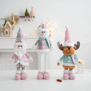 Detail of Christmas plush dolls in pink and mint green sitting on a festive fireplace mantel