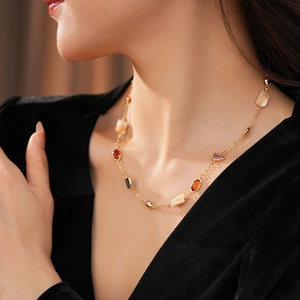Détail du collier vintage avec pierres géométriques colorées sur une chaîne dorée