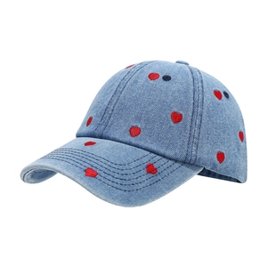Blue denim baseball cap with red heart embroidery pattern on white background
