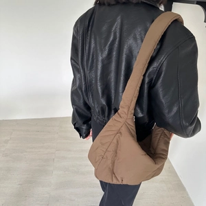 Brown quilted crossbody bag detail showing the padded sponge texture on a female model
