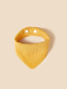 Detail of yellow cotton muslin baby bib with crinkle texture and adjustable snaps