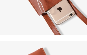 Close-up of brown mini phone bag showing lychee leather texture and precise stitching
