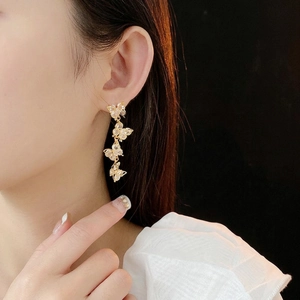 Elegant gold butterfly tassel earrings with sparkling zircon drop pendants on model