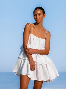 Detail of multi-layered white ruffles and high-quality fabric on backless summer dress