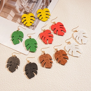 Six pairs of tropical monstera leaf wooden earrings in vibrant colors with gold hooks