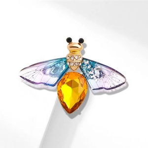 Golden bee brooch with blue-purple wings and a large yellow crystal body accent