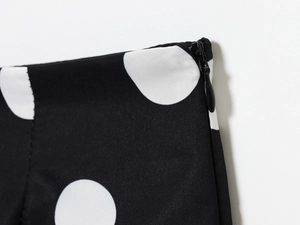 Detail of high waist polka dot shorts showing invisible back zipper and fabric texture