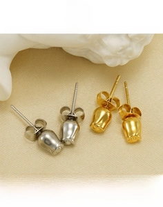 Makro-Detail von Tulpenknospen-Ohrsteckern aus Titanstahl in Gold und Silber