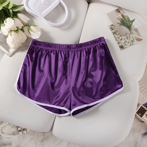 Flat lay of purple satin athletic shorts with white piping on a white sofa