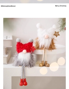 Detailed view of plush Christmas long-legged gnomes sitting on white books with warm lighting