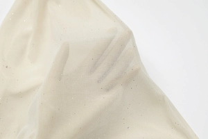Makroaufnahme von beigem Netzstoff mit feinen Glitzerpartikeln und transparenter Textur