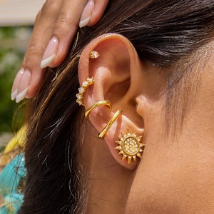 Golden sun-shaped stud earrings with rhinestones and ear cuff set worn by model