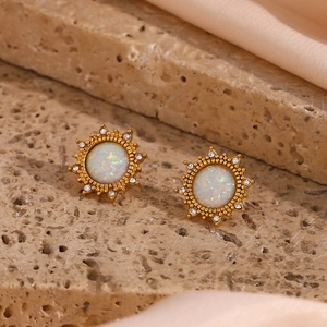 Macro shot of gold-plated opal stud earrings with sunflower starburst design and crystals