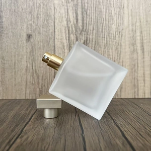 Detail of square frosted glass perfume bottle with a premium gold metallic sprayer