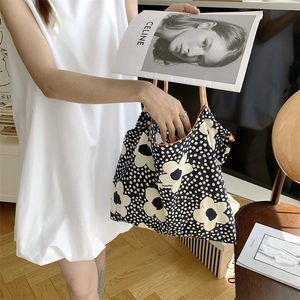 Detail of floral tote bag with orange piping shown in a lifestyle home setting