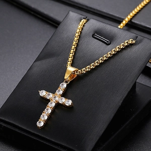 Macro shot of hip hop gold cross pendant with clear zircon inlay on a box chain
