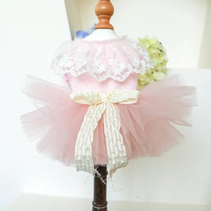 Close-up of pink pet dress with white floral lace, tulle tutu and beige bow ornament