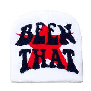 Détail du bonnet blanc en maille avec texte noir et motif jacquard d'étoile rouge