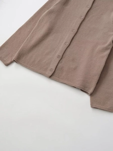 Detailed macro view of mocha brown knit cardigan showing buttons and fabric texture