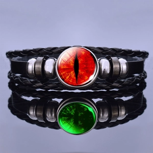 Close-up of leather bracelet with red dragon eye gemstone on reflective surface
