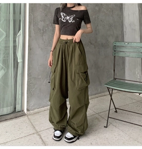 Detailed view of olive green multi-pocket cargo pants with butterfly print crop top outfit
