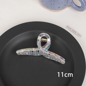 Detail shot of 11cm iridescent transparent hair claw clip on a minimalist tray