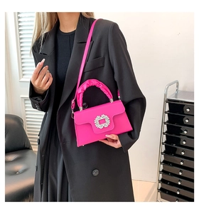 Detail of rose pink handbag with pleated handle and sparkling sunflower rhinestone buckle