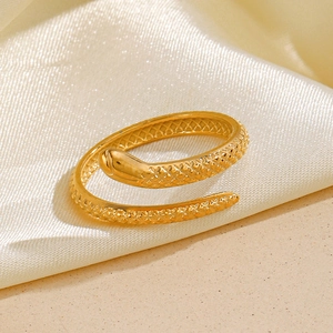 Vintage golden snake ring with detailed scale texture on elegant silk background